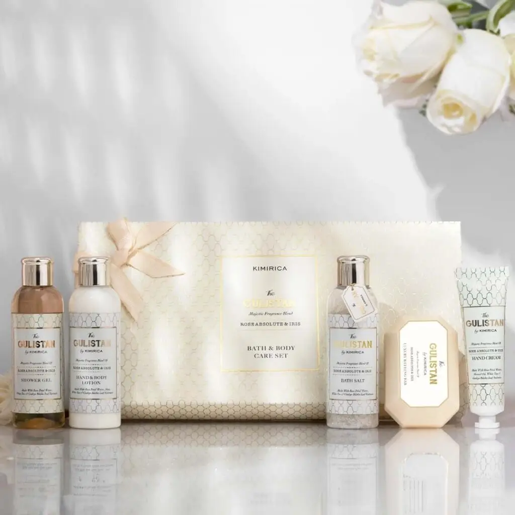 Showcase of Kimirica’s bath and body care collection with white roses.