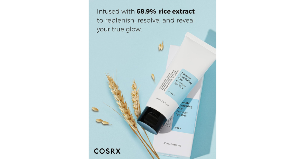 A tube of COSRX Ultimate Nourishing Rice Overnight Spa Mask against a pastel blue background, accompanied by stalks of rice.